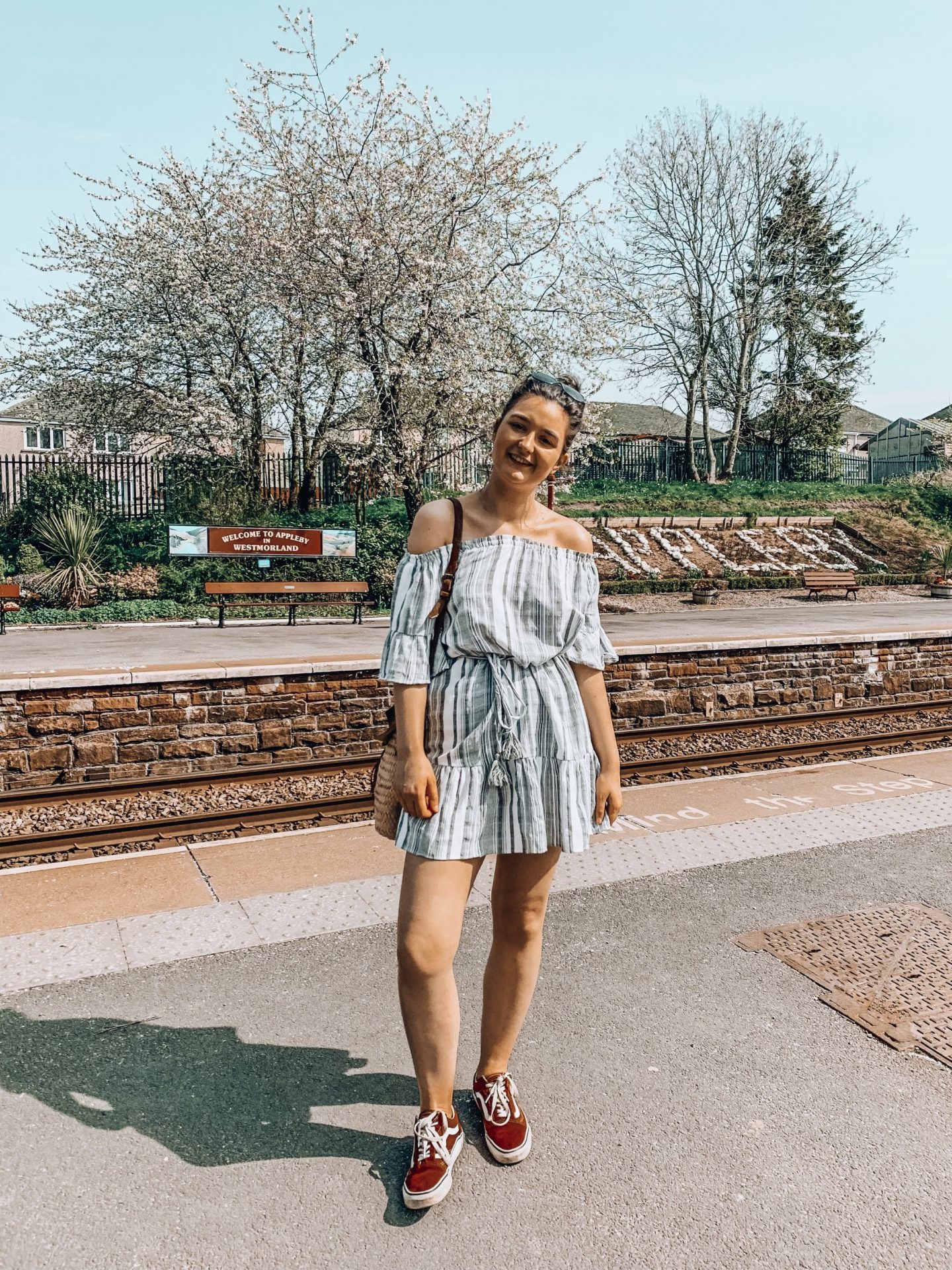 Am I Disabled? | Girl stood at old fashioned train station with blue sky in summer dress