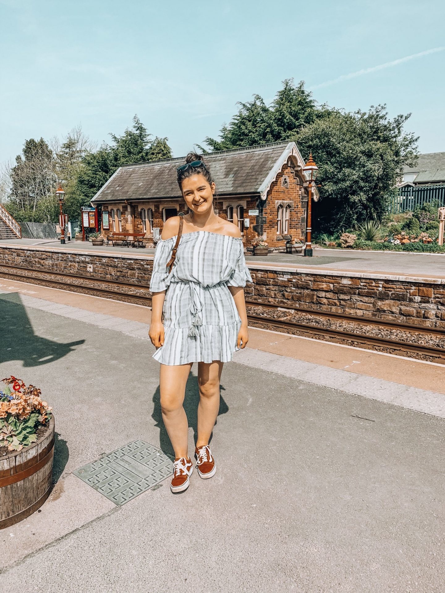 Am I Disabled? | Girl stood at old fashioned train station with blue sky in summer dress