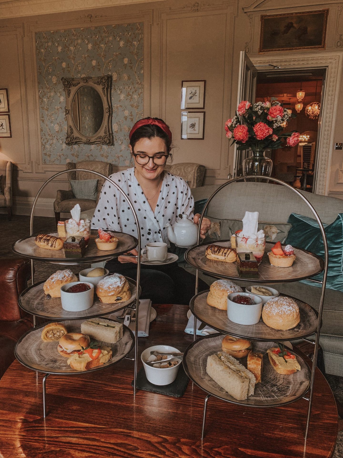 Afternoon tea at the Laura Ashley hotel, The Belsfield | Girl sat in Laura Ashley grand hotel with two afternoon tea sets