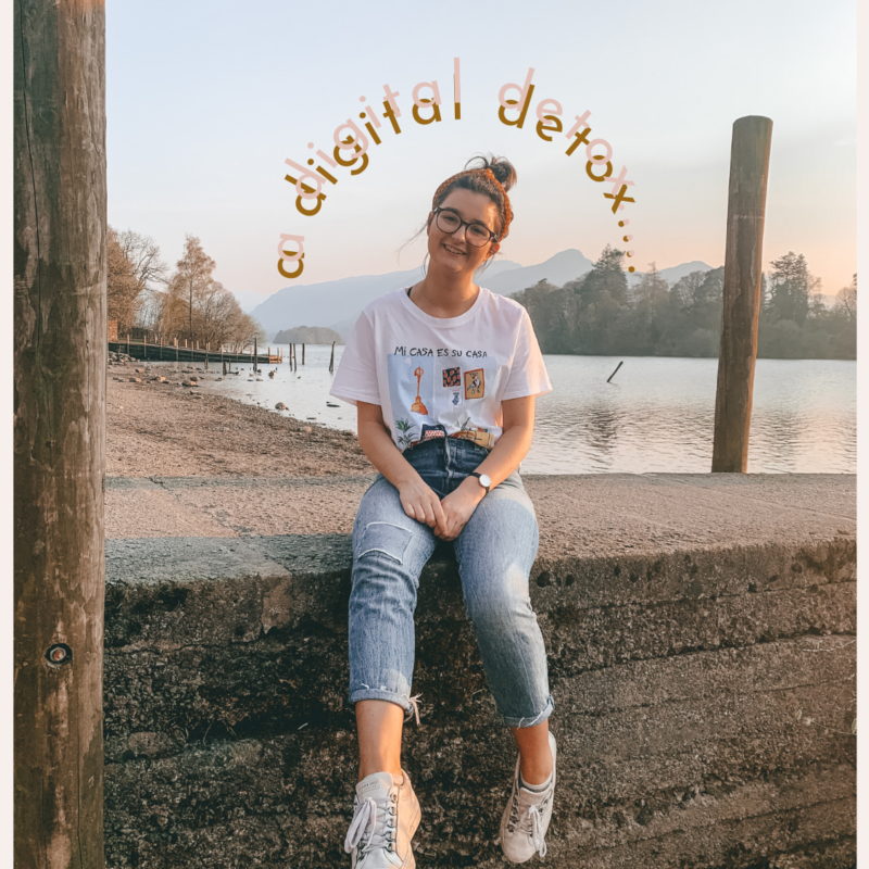 Postcard with Katie May sat by a lake with the words "a digital detox..." in pink over her head